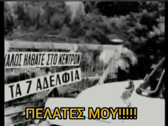a black and white photo of a car with a sign that says ta 7 adelpia