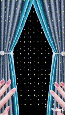 a woman 's fingers are reaching out towards a blue curtain
