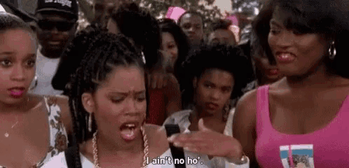 a group of women are standing next to each other in a crowd and one of them is screaming .