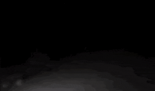 a person is walking through the snow at night .