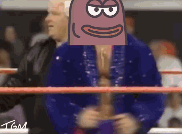 a man in a wrestling ring has a cartoon face on his head with the number 8 on it