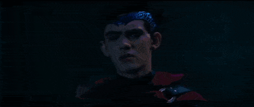 a person is standing in the dark with a blue light coming out of their hands .