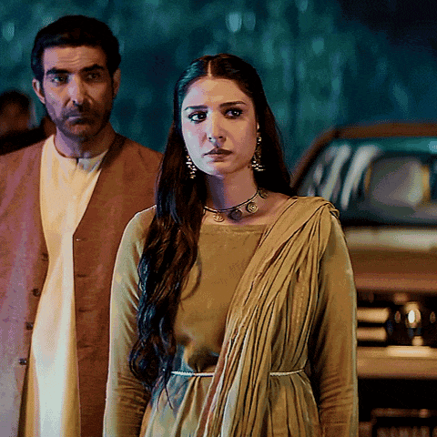 a man and a woman standing in front of a car