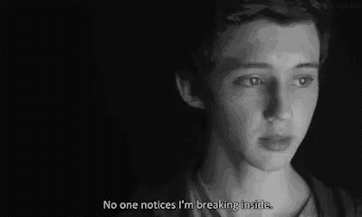 a black and white photo of a young man looking at a computer screen .