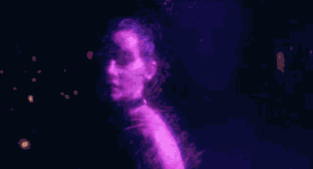 a woman in a red dress is surrounded by purple and blue lights .