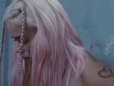 a woman with pink hair is wearing a bandana
