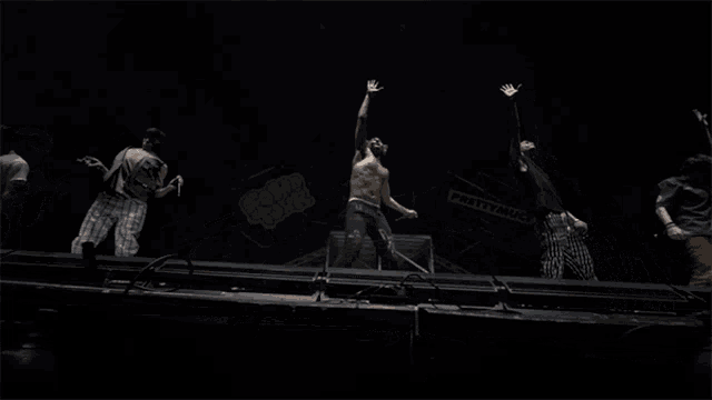 a group of men are dancing on a stage in front of a sign that says heavy metal