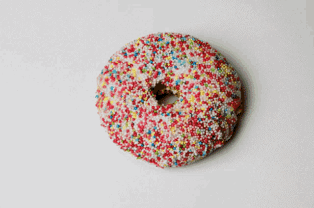 a donut with white frosting and sprinkles on it