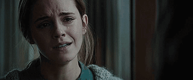 a woman is crying with a tear running down her cheek .