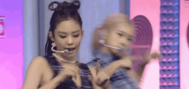 a group of women are dancing on a stage while wearing microphones .