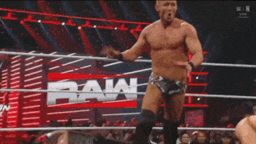 two men are wrestling in a ring with a sign that says ' elimination chamber '