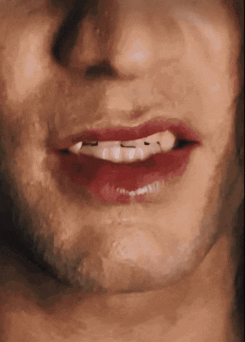 a close up of a man 's mouth with red lipstick and white teeth