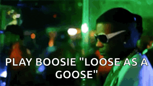 a man wearing sunglasses says play boosie " loose as a goose " in front of a crowd