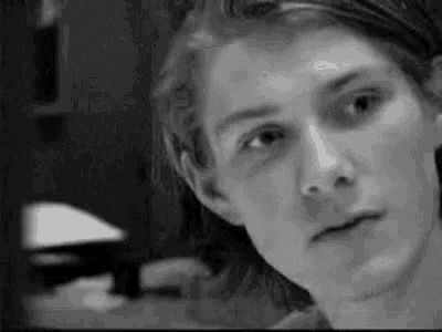a black and white photo of a young man 's face .