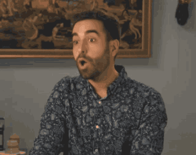 a man in a blue shirt is making a stop gesture with his hand