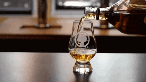 a bottle of alcohol is being poured into a glass