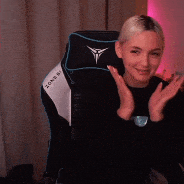 a woman is sitting in a black and white zone 51 chair