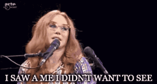 a woman singing into a microphone with the words i saw a me i did n't want to see