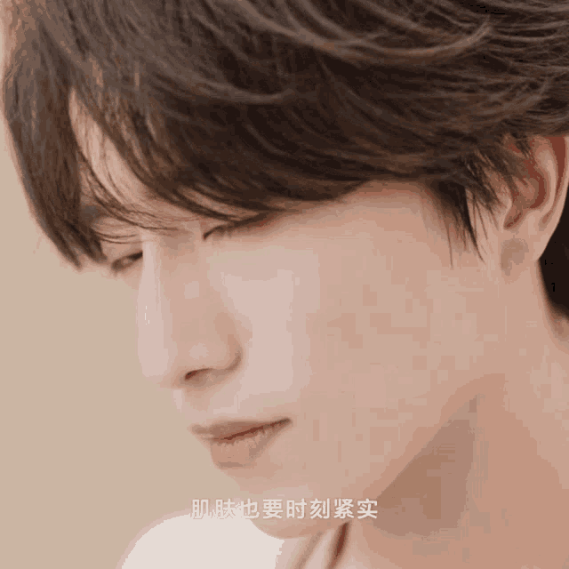 a close up of a man 's face with chinese writing on the bottom right