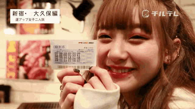 a woman holding a ticket that says lotto 6