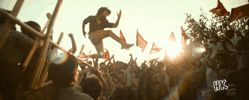 a man is jumping in the air in front of a crowd with the letters hk on the bottom right