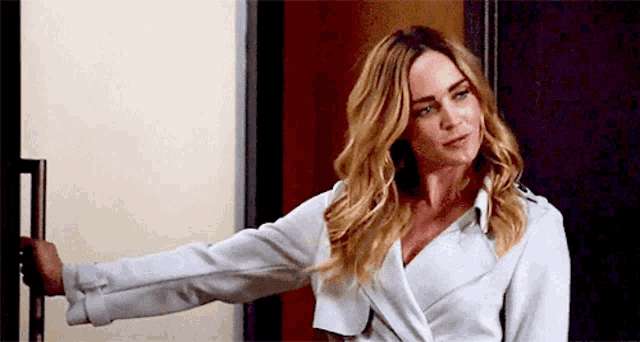a woman in a white coat is standing in front of a door .