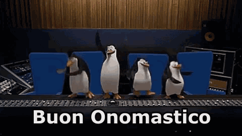 a group of penguins are dancing in front of a keyboard with the words buon onomastico written below them