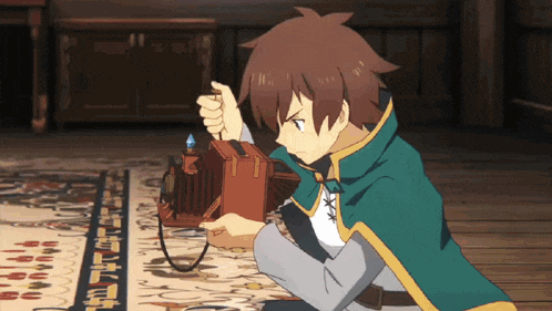 a man in a green cape is kneeling down and holding a camera