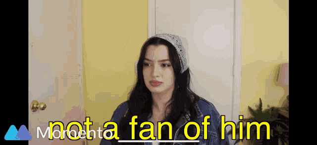 a woman wearing a bandana and a denim jacket says she is not a fan of him