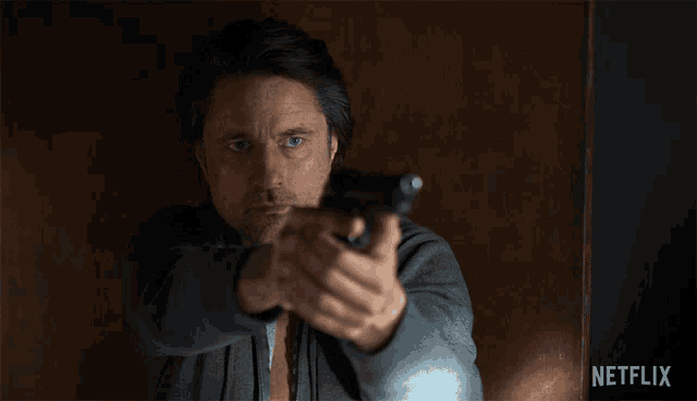 a man pointing a gun with a netflix logo in the background