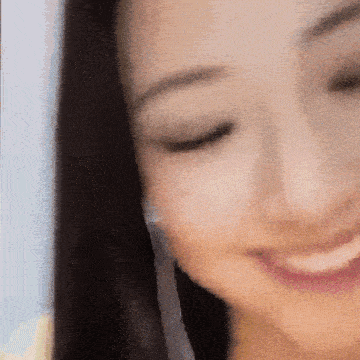 a close up of a woman 's face with her eyes closed smiling