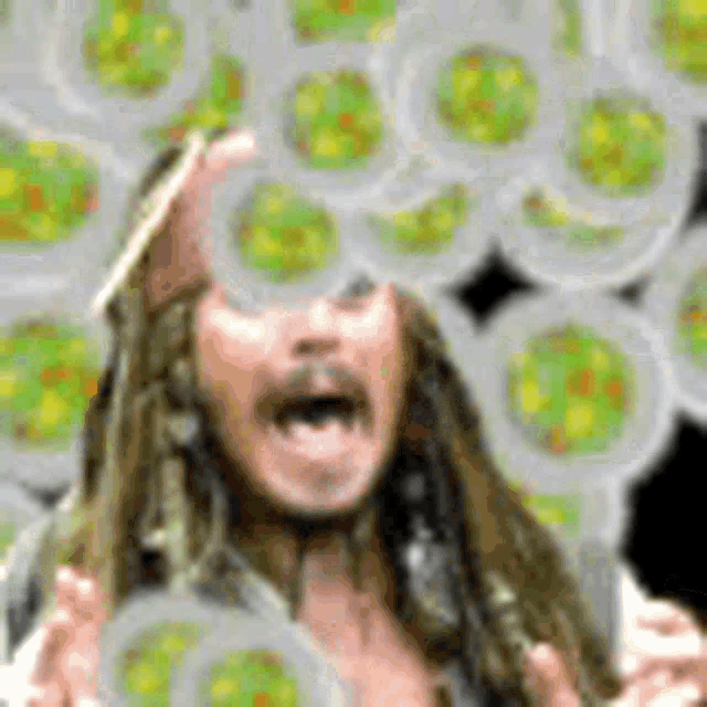 a man with long hair and a beard is standing in front of a bunch of plates with green circles on them .
