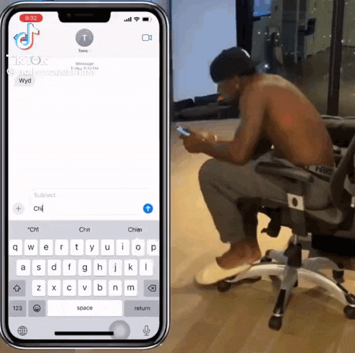 a shirtless man is sitting in an office chair looking at his cell phone