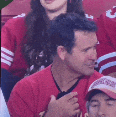 a man wearing a red shirt that says ' sonics ' on it