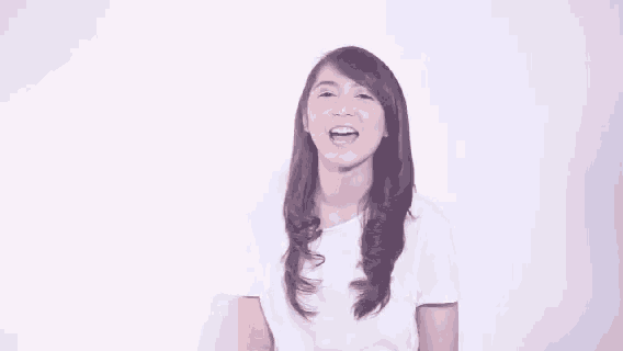 a young woman in a white shirt is smiling and looking up .