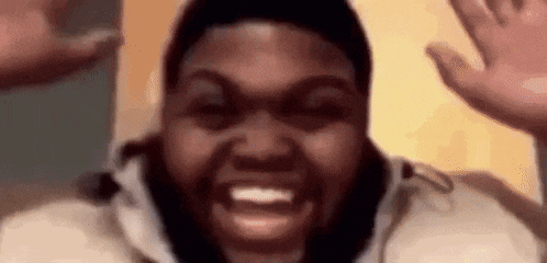 a man with a beard is making a funny face with his hands up .