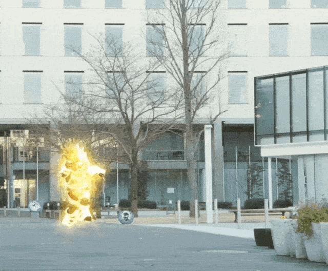 a person is on fire in front of a building with a skull in the background
