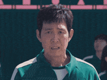 a man in a green shirt is standing in front of a group of people