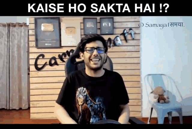 a man wearing glasses and a t-shirt that says ' kaise ho ' on it