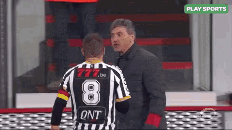 a soccer player with the number 8 on his jersey is talking to another player