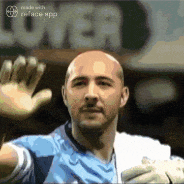 a bald man in a blue shirt is waving his hand in front of a sign that says lower