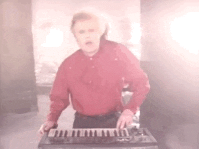 a man in a red shirt is playing an electronic keyboard .