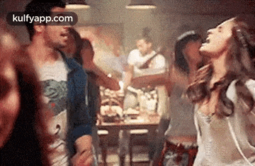 a group of people are dancing in a room at a restaurant .
