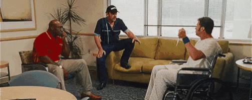 a man in a wheelchair is talking to two other men