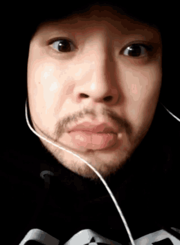 a man with a beard wearing headphones and a black hoodie