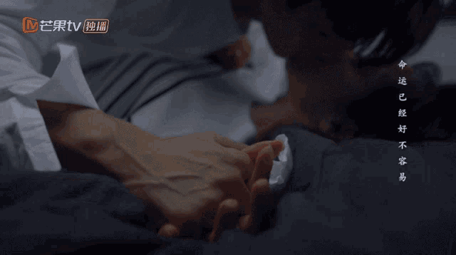 a close up of a person holding another person 's hand with an orange tv logo in the corner