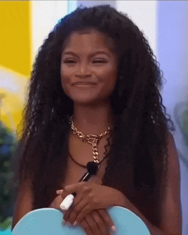 a woman with curly hair wearing a necklace and a ring