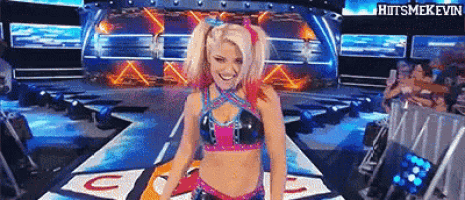 a woman in a wrestling outfit is standing on a stage with a sign that says g on it .