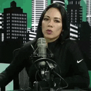 a woman is sitting in front of a microphone with headphones on .