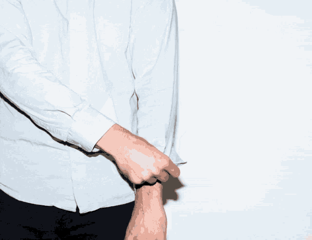 a man in a white shirt is holding his elbow up